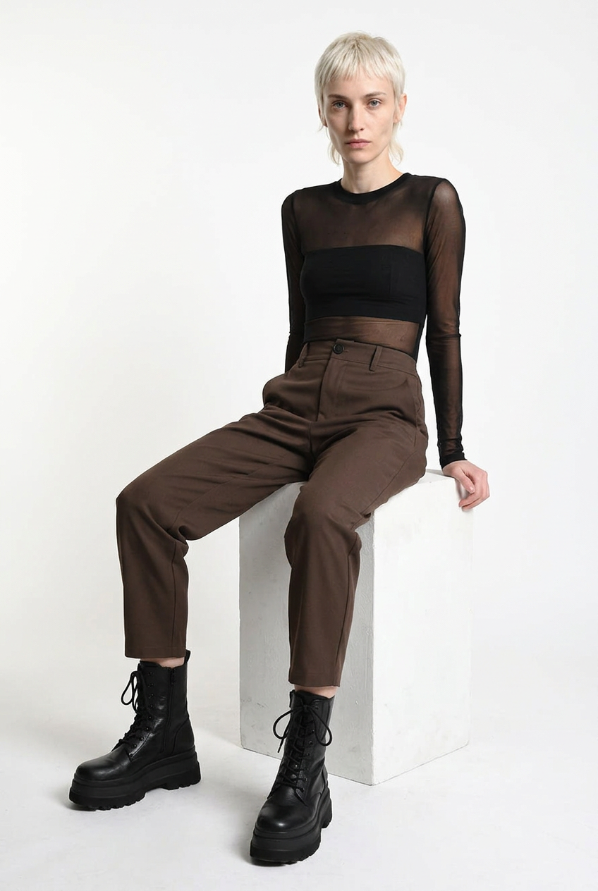 LA HAINE INSIDE US brown carrot-fit trousers, seated three-quarter front view
