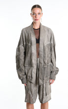 Person wearing a gray textured cardigan with a white background