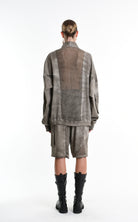 Person wearing a textured outfit with a coat and shorts on a white background, featuring the brand 'La Haine Inside Us'.