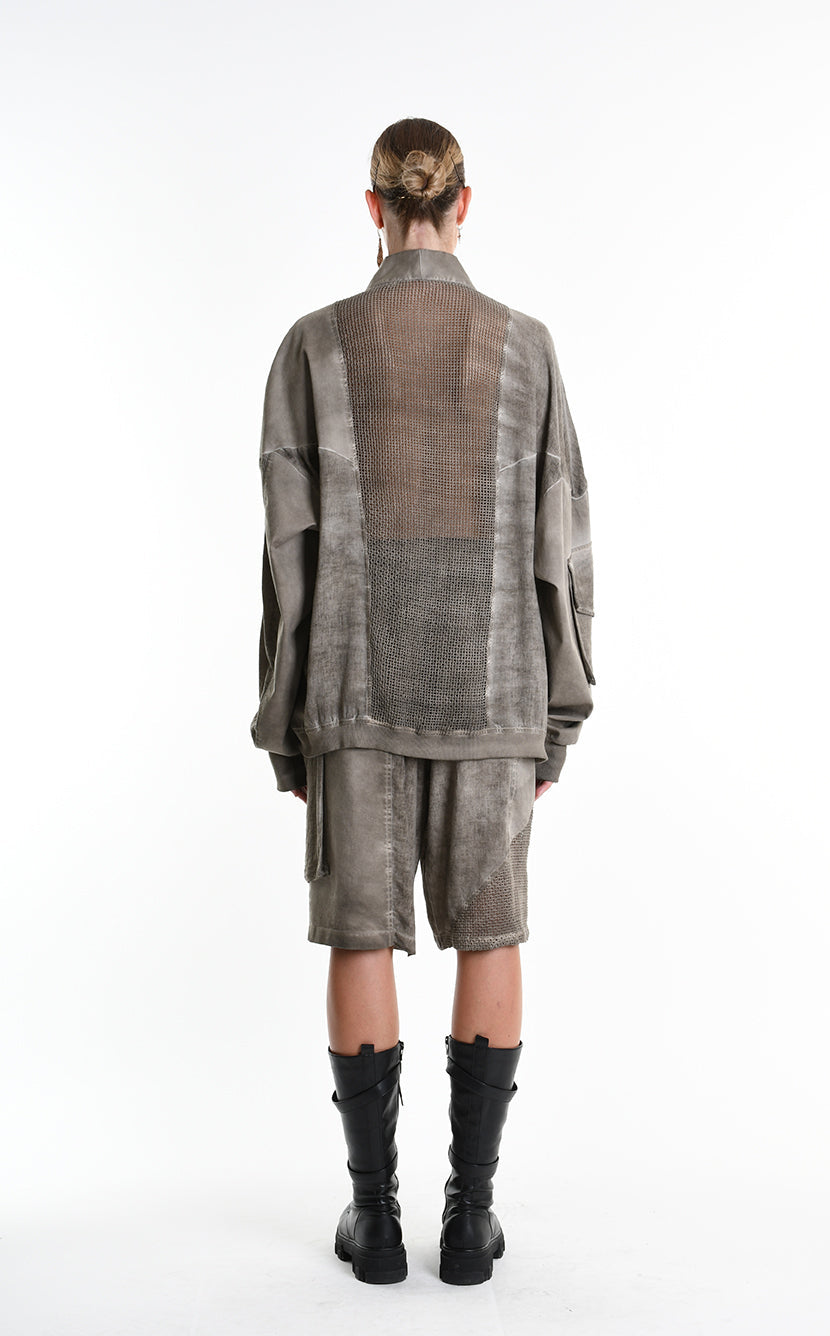 Person wearing a textured outfit with a coat and shorts on a white background, featuring the brand 'La Haine Inside Us'.