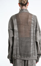 Person wearing a textured jacket with mesh back panel on a plain background