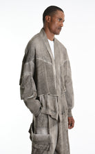 Man wearing a textured gray cardigan and pants with 'La Haine Inside Us' text on a white background