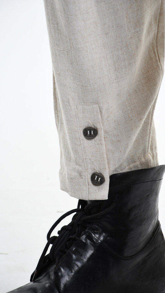 A33M M101225 Trouser with buttons, ecru fabric, near black boot.