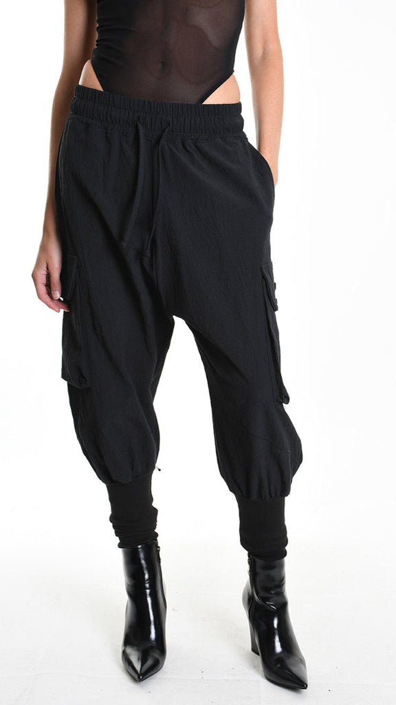 Unisex black baggy jacquard trousers with elastic waist, ribbed bottom, and pockets.