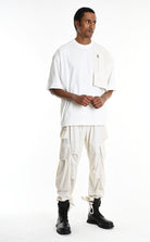 Man wearing a white outfit with cargo pants on a white background, featuring the text 'LA HAINE INSIDE US'.