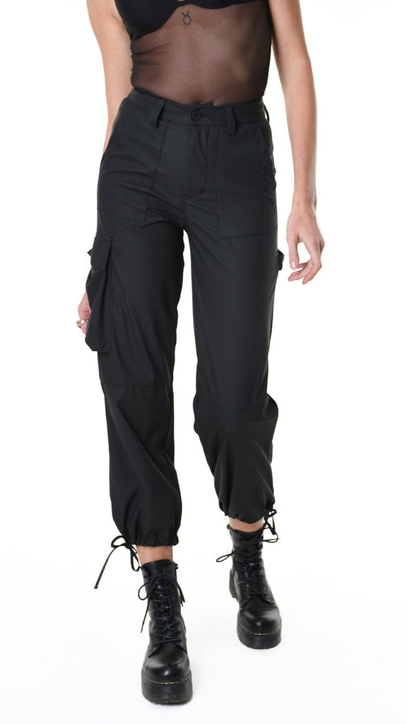 Black stretch trousers made from rubberized technical fabric with pockets and elasticated cuffs.