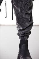 M P 21 – Used Grey Men’s cargo trousers in washed grey with zip/flap pockets, drawstring waist, and elastic cuffs THOM KROM