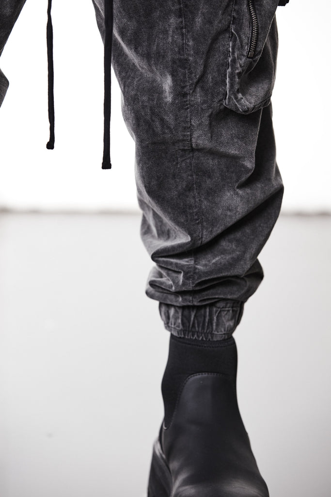 M P 21 – Used Grey Men’s cargo trousers in washed grey with zip/flap pockets, drawstring waist, and elastic cuffs THOM KROM