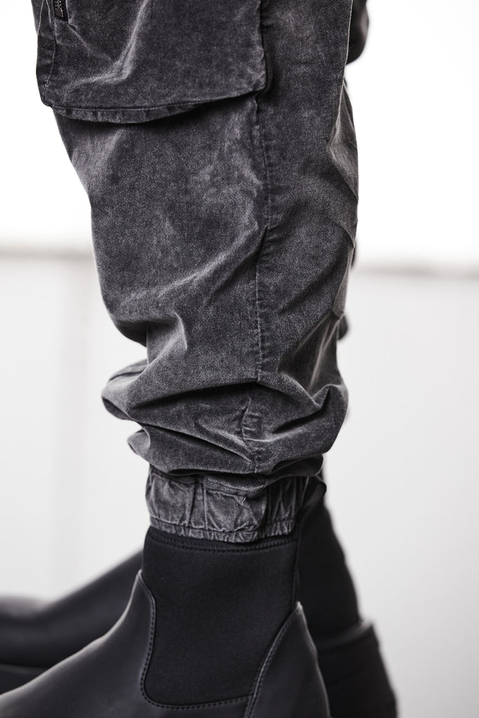 M P 21 – Used Grey Men’s cargo trousers in washed grey with zip/flap pockets, drawstring waist, and elastic cuffs THOM KROM
