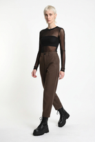 LA HAINE INSIDE US brown carrot-fit trousers, three-quarter walking view