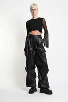 LA HAINE INSIDE US W5468 faux leather trousers in black — three-quarter front editorial view