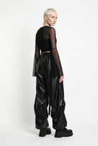 LA HAINE INSIDE US W5468 faux leather trousers in black — rear three-quarter editorial view