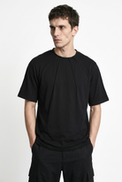 LA HAINE INSIDE US M1375 black oversized cotton stretch T-shirt, front view with hands in pockets