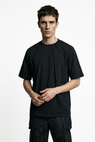 LA HAINE INSIDE US M1375 black oversized cotton stretch T-shirt, front view with hands clasped
